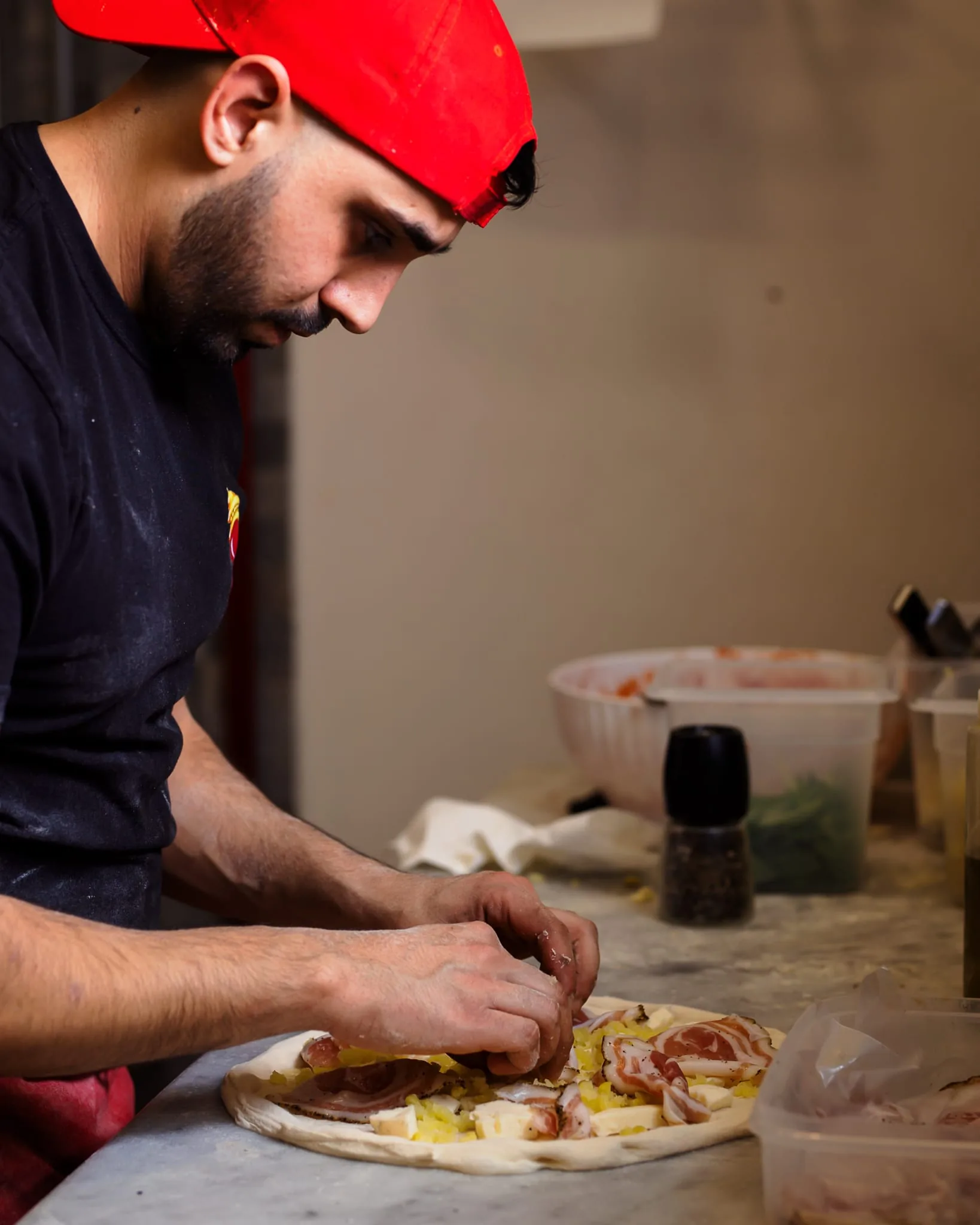 Pizza guarnita al banco con ingredienti freschi